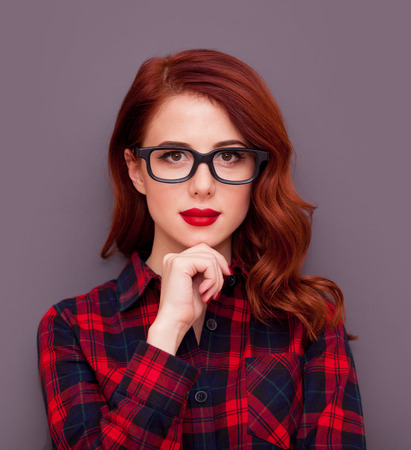 Redhead girl in glasses on grey backgroundの写真素材