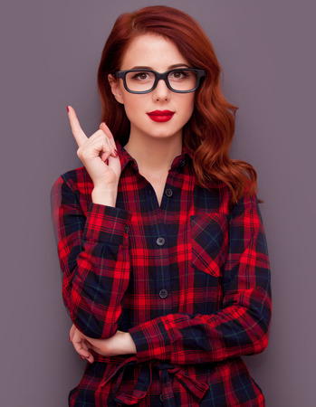 Redhead girl in glasses on grey backgroundの写真素材