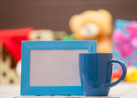 Cup of coffee or tea with blue photo frame on christmas backgroundの写真素材