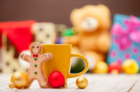 Cup of coffee or tea with gingerbread man on christmas backgroundの写真素材