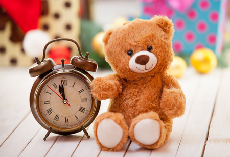 Alarm clock and teddy bear on christmas backgroundの写真素材