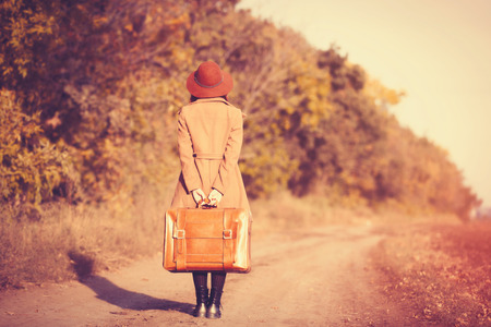 woman with bag at countryside in autumn timeの写真素材