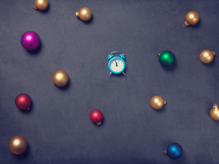 Christmas baubles and alarm clock on grey backgroundの写真素材