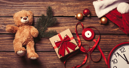 Christmas gift-ready for packaging and teddy bear toy on a wooden backgroundの写真素材