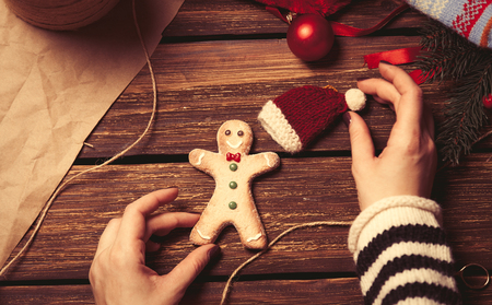 Woman wrapping a christmas cookie on wooden background, photo from high point of viewの写真素材