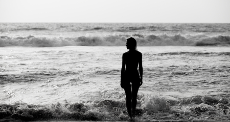 Silhouette of a young woman in the seaの写真素材