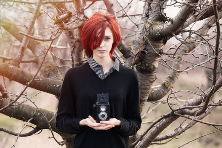 Young woman with vintage camera at outdoorの写真素材