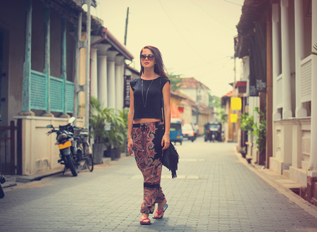 portrait of a beautiful young woman walking in the middle of the streetの写真素材