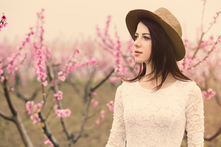 portrait of beautiful young woman  near blooming treeの写真素材