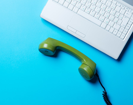 green handset and laptop on the blue backgroundの写真素材