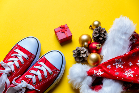 photo of the beautiful Christmas decorations, red gumshoes and gift on the yellow backgroundの写真素材