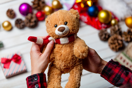 photo of the child  hands holding cute teddy bear on the christmas decorations backgroundの写真素材