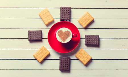 photo of the cup of coffee and cookies on the white wooden backgroundの写真素材