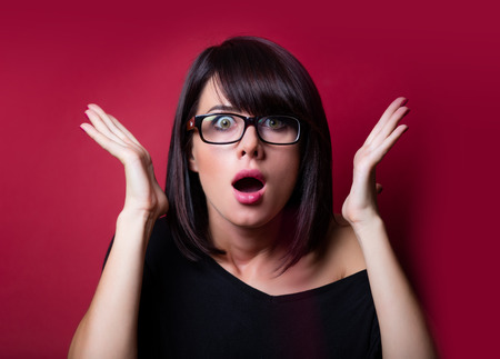 portrait of the beautiful surprised young woman on the vinous backgroundの写真素材