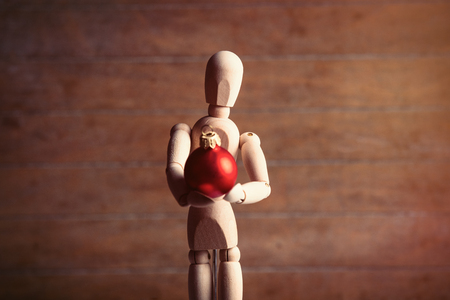 photo of the beautiful gestalta with red bauble on the brown wooden backgroundの写真素材