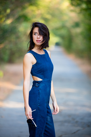 portrait of the beautiful young woman standing in the middle of the roadの写真素材