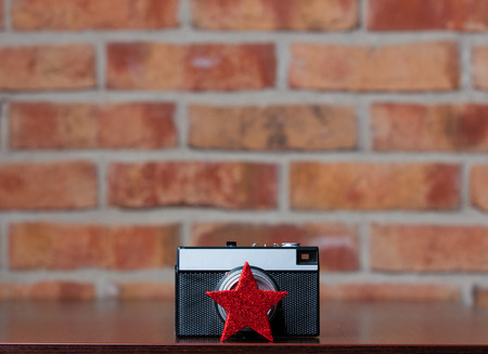 Retro camera and little red star on brick wall backgroundの写真素材