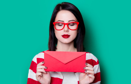Brown hair girl with envelope on green background.の写真素材