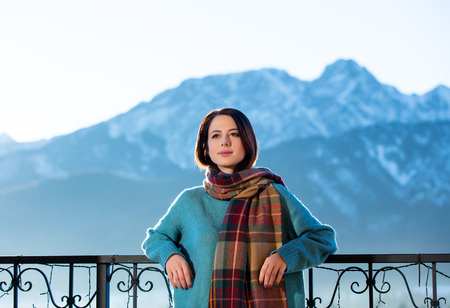Portrait of a young redhead woman with mountains on background