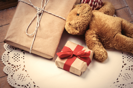 beautiful gifts and cute teddy bear on white napkin on the wonderful brown wooden backgroundの写真素材