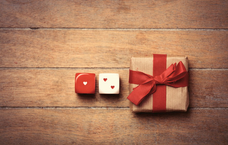 beautiful gift and small dice on the wonderful brown wooden background