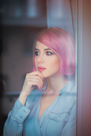 beautiful young woman looking at the window and thinkingの写真素材