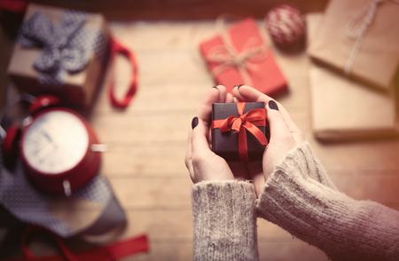 beautiful woman hands holding cute gift on the wonderful decoration backgroundの写真素材