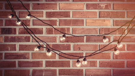 beautiful bright garland on the wonderful red brick backgroundの写真素材