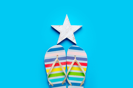 colorful sandals and beautiful star shaped toy on the wonderful blue backgroundの写真素材