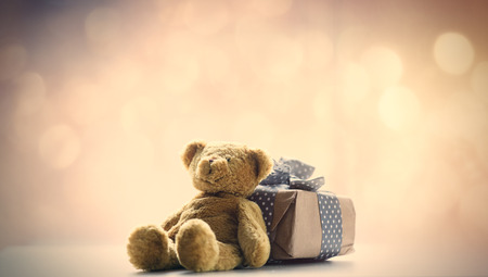 cute teddy bear and beautiful gift on the fairy lights bokeh backgroundの写真素材