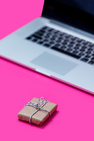 beautiful small gift and cool laptop on the wonderful pink backgroundの写真素材