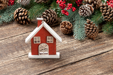 photo of house shaped toy near christmas decorations on the wonderful brown wooden backgroundの写真素材
