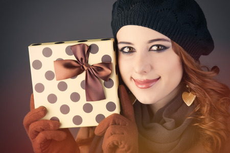 portrait of beautiful young woman with cute gift on the wonderful grey studio backgroundの写真素材