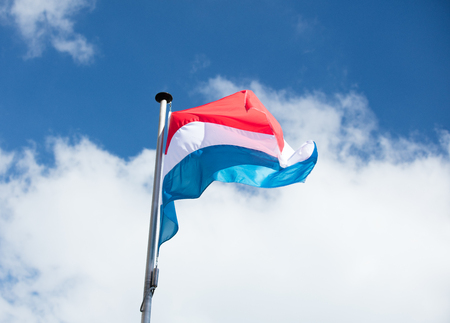 photo of beautiful colorful flag of France on the wonderful blue skyの写真素材