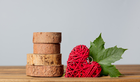 heart shape toy and maple tree leaf on grey backgroundの写真素材