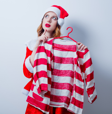 Portrait of Young Santa Clous girl in red clothes with shirt on white backgroundの写真素材