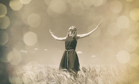 girl at wheat field in summer day. Photo in sepia color image styleの写真素材