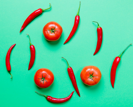 Above view at Chili pepper and tomatoes on green backgroundの写真素材