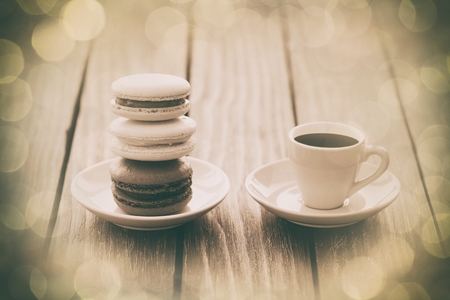 Cup of coffee and macarons on old wooden table.の写真素材