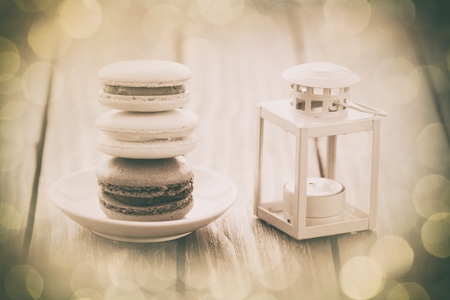 Macarons and little decorate lamp on wooden table.の写真素材