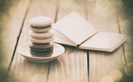 Macarons and little notebook on wooden table.の写真素材