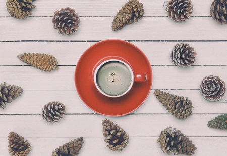 Cup of coffee and pine cone on a white table.の写真素材