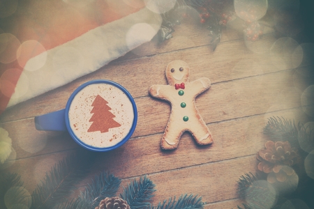 Coffee with gingerbread man on wooden table.の写真素材