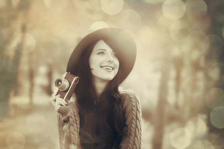 Brunette girl with camera in the park in sunset timeの写真素材