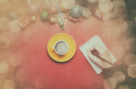 hand writing something in to the notebook near christmas toys.の写真素材