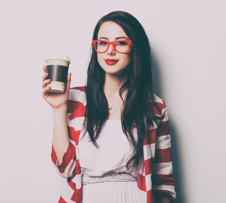 portrait of the beautiful young woman with cup of coffee on the white backgroundの写真素材