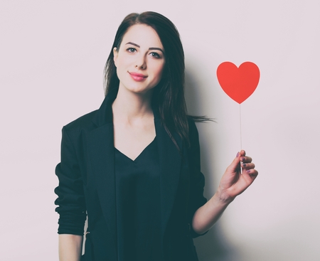 portrait of the beautiful young woman with heart shaped toy on the white backgroundの写真素材