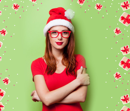 Portrait of a smiling women in christmas hat on grey background.の写真素材