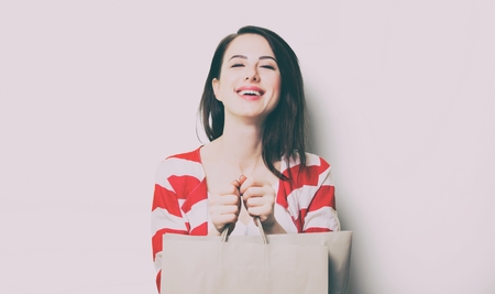 portrait of the beautiful young woman with shopping bags on the white backgroundの写真素材