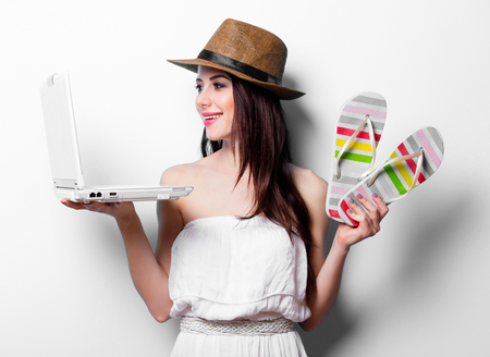 portrait of the beautiful young woman with laptop and sandalsの写真素材